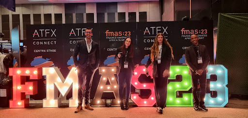 Four members of the Inbound FinTech team in attendance at the Finance Magnates Africa Summit 2023, standing in front of a colourfully illuminated 3D sign reading “FMAS23”